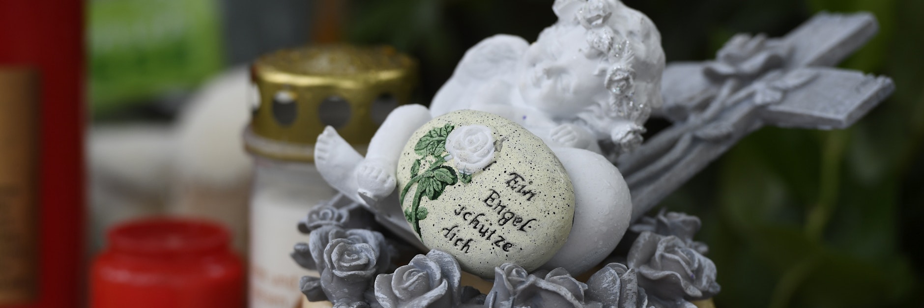 Eine Engelsfigur und Kerzen liegen vor einem Haus. Eine 27-jährige Mutter soll in Solingen fünf Kinder umgebracht haben.