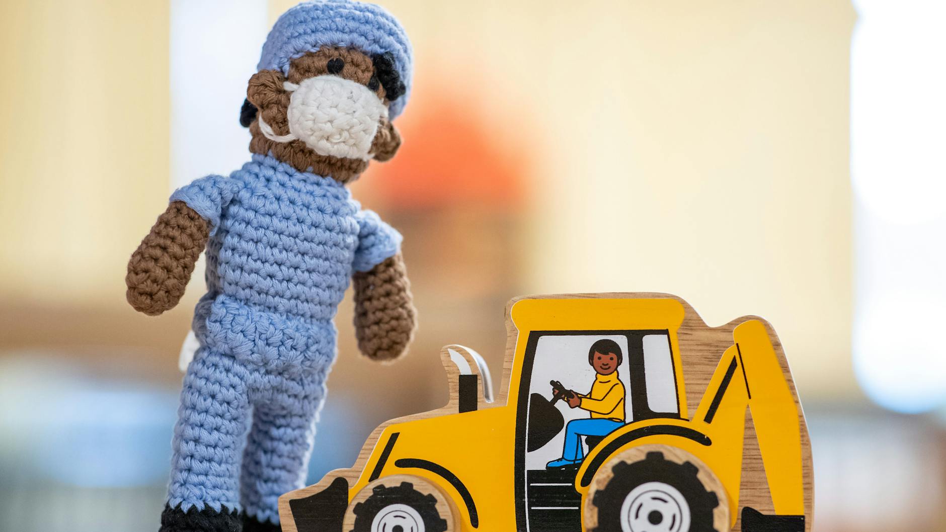 Spielzeug, das nach Aussagen von Mitarbeiterinnen des Museums anti-rassistisch gestaltet sein soll, steht im Spielzeugmuseum Nürnberg auf einem Tisch. Es handelt sich um eine Puppe, die einen Krankenpfleger darstellen soll, und einen Holzbagger mit Fahrer.