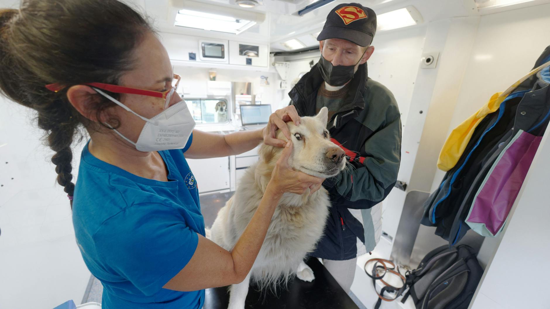 Tierärztin Claudia Gomez (li.) behandelt im Tierarztmobil den Hund Knut von Gunar Beckers (re.).