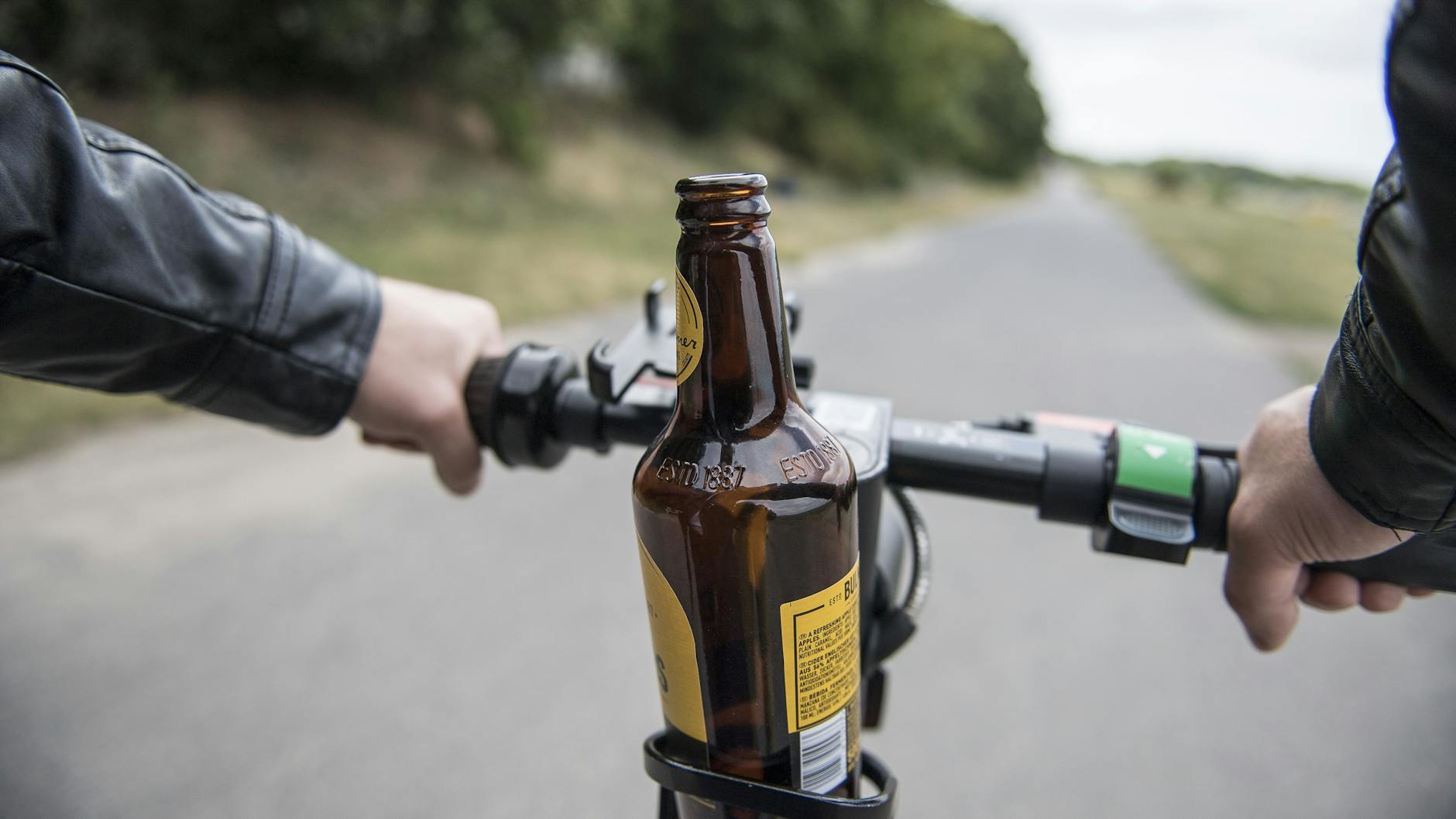 Eine Bierflasche steht in einer Getränkehalterung auf einem E-Scooter. Alkohol ist das häufigste Fehlverhalten bei E-Scooter-Fahrern.