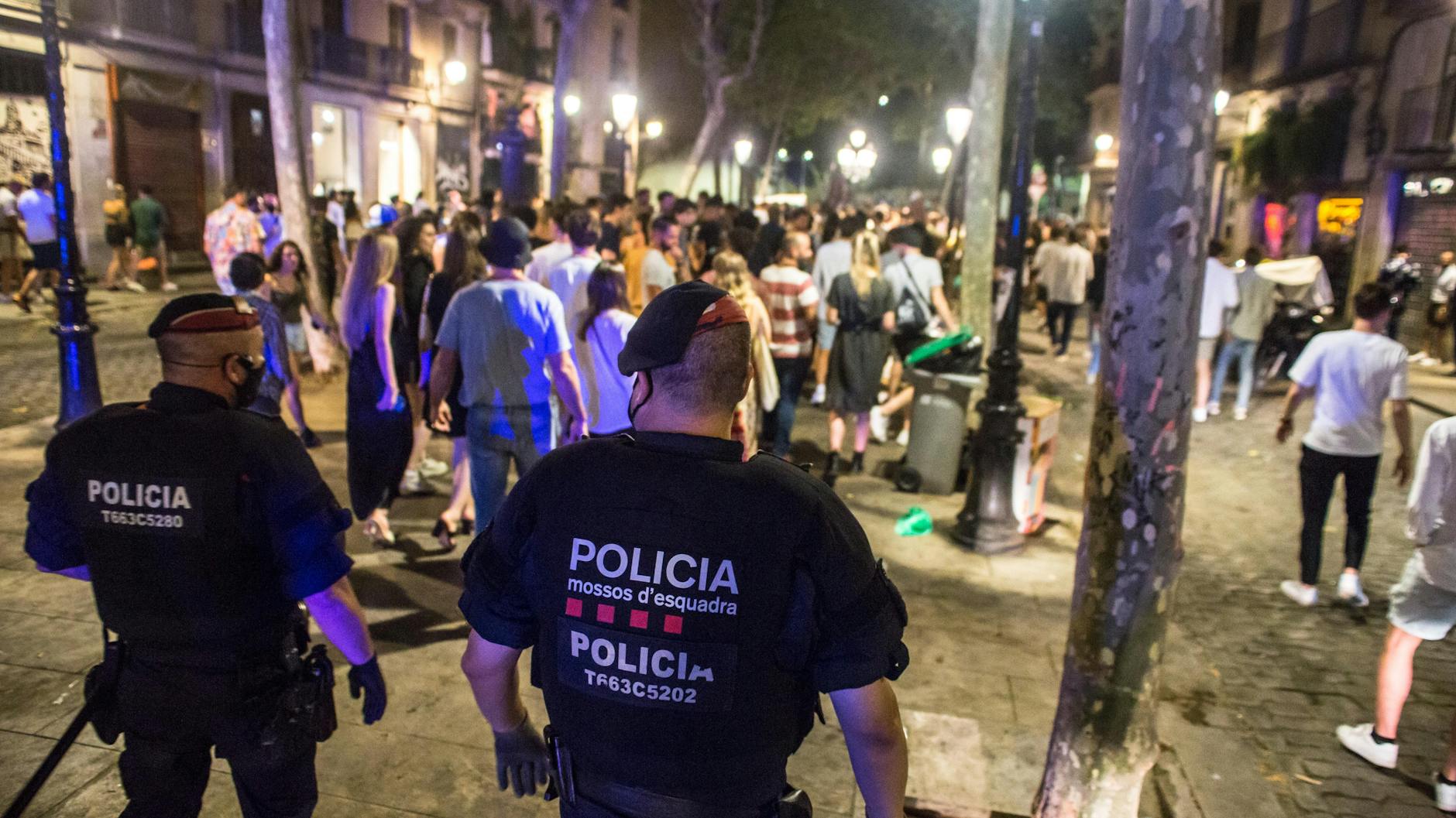 Barcelona: Polizisten vertreiben junge Menschen, die sich nachts auf der Straße versammelt hatten. Zur Eindämmung der schon seit Tagen rasant steigenden Infektionszahlen schränkt der spanische Corona-Hotspot Katalonien nächtliche Aktivitäten weiter ein. 