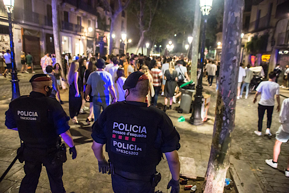 Barcelona: Polizisten vertreiben junge Menschen, die sich nachts auf der Straße versammelt hatten. Zur Eindämmung der schon seit Tagen rasant steigenden Infektionszahlen schränkt der spanische Corona-Hotspot Katalonien nächtliche Aktivitäten weiter ein.&nbsp;