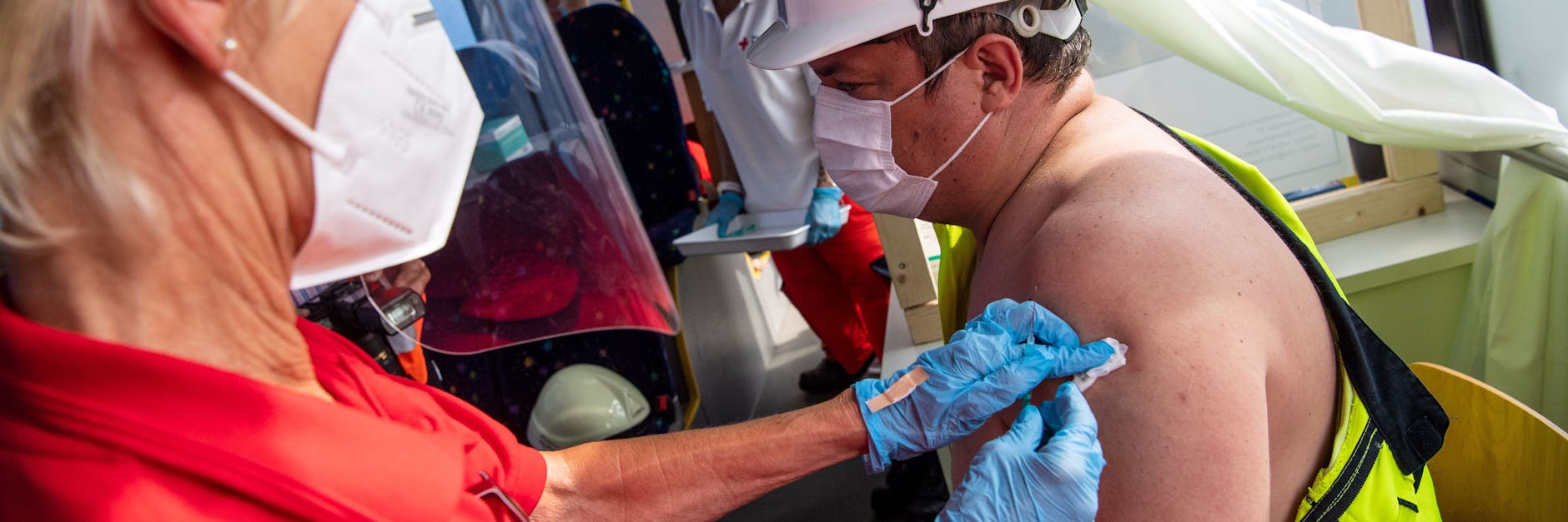 Geimpft wird nun zunehmend dort, wo sich die Impflinge aufhalten: Ein Seefahrer wird in einem Bus des Deutschen Roten Kreuzes am Hafen in Bremerhaven geimpft.