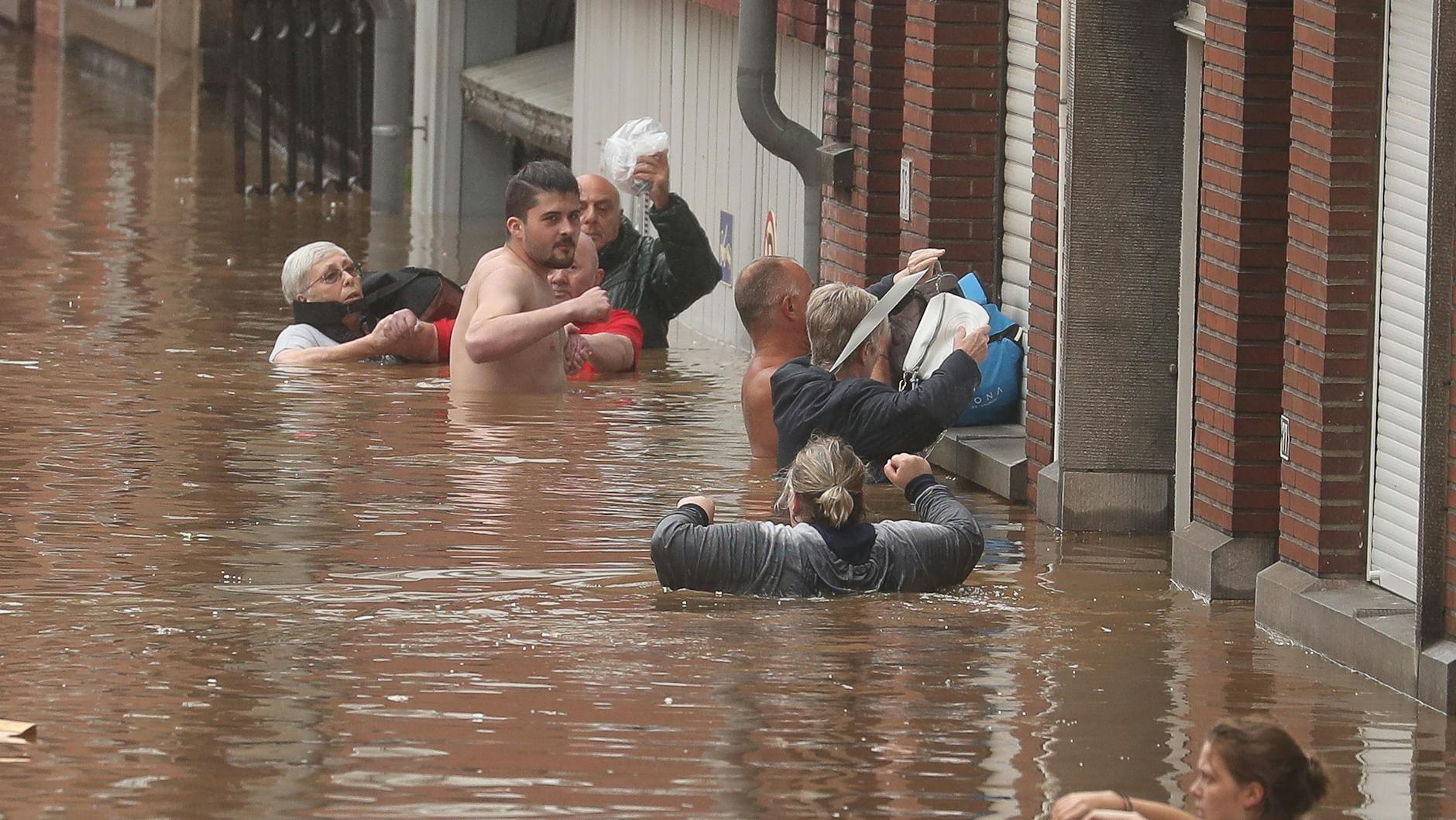 Im Lüttich waten die Menschen durch das Hochwasser. 
