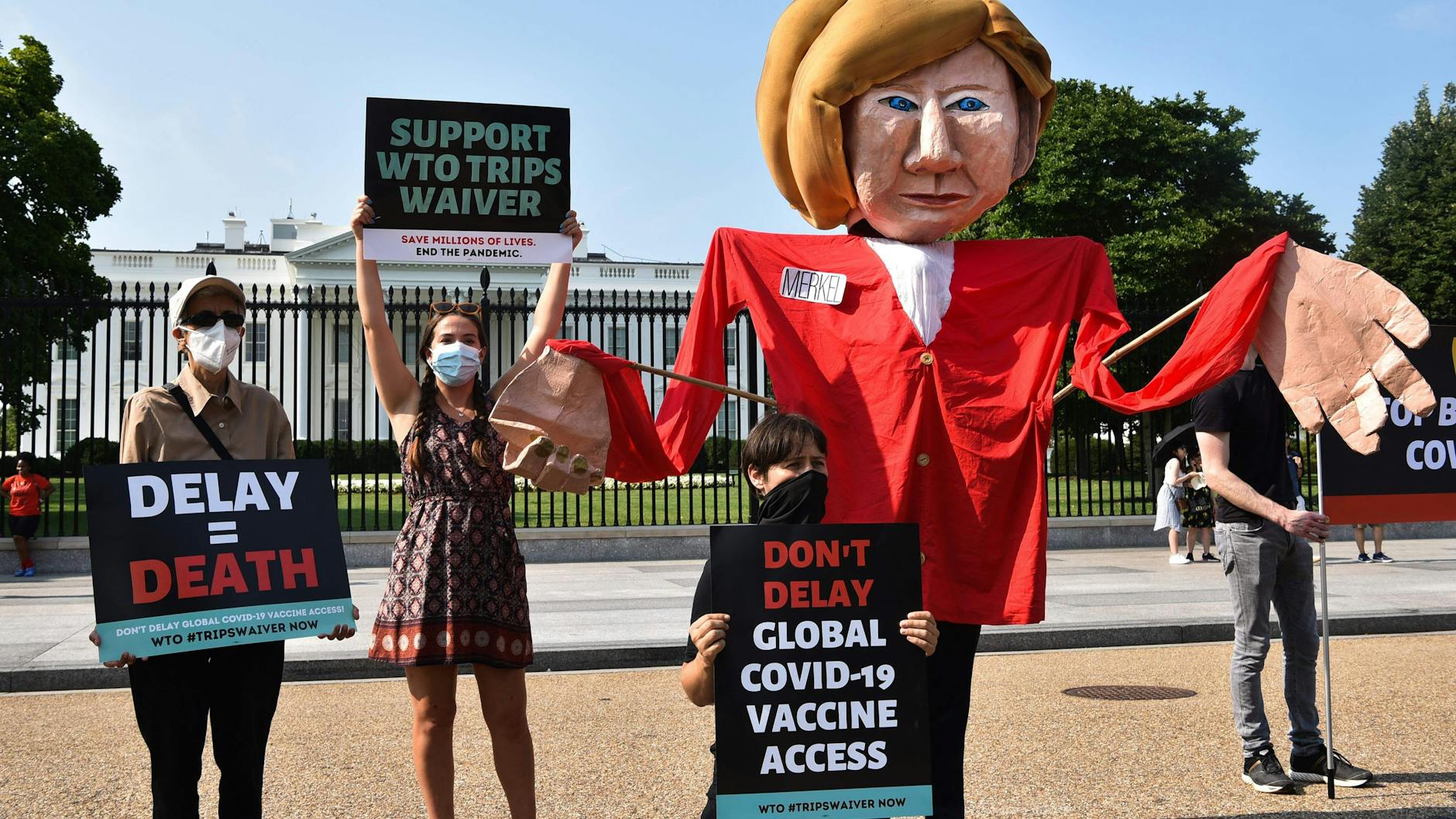 Demonstranten fordern von Merkel, der Aussetzung des Patentschutzes für Corona-Impfstoffe zuzustimmen.