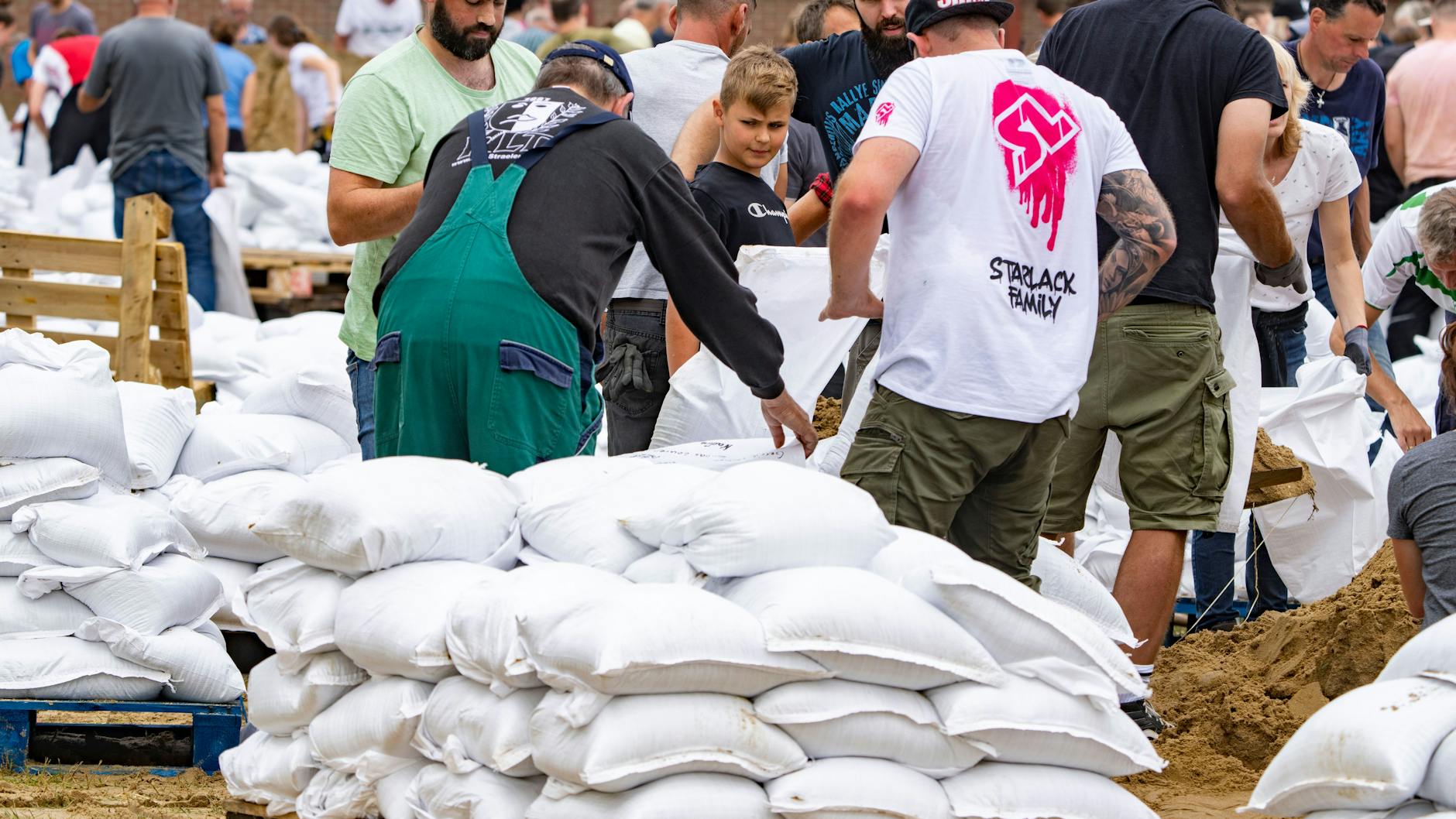 Viele Helfer füllen im Stadtteil Velden Sandsäcke. Die Maas tritt nach den Unwettern der letzten Tage über die Ufer. Mit den Sandsäcken soll der Damm gefestigt und erhöht werden, in der Nacht zum Samstag wird hier der Höchststand erwartet.