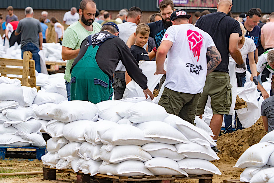 Viele Helfer füllen im Stadtteil Velden Sandsäcke. Die Maas tritt nach den Unwettern der letzten Tage über die Ufer. Mit den Sandsäcken soll der Damm gefestigt und erhöht werden, in der Nacht zum Samstag wird hier der Höchststand erwartet.