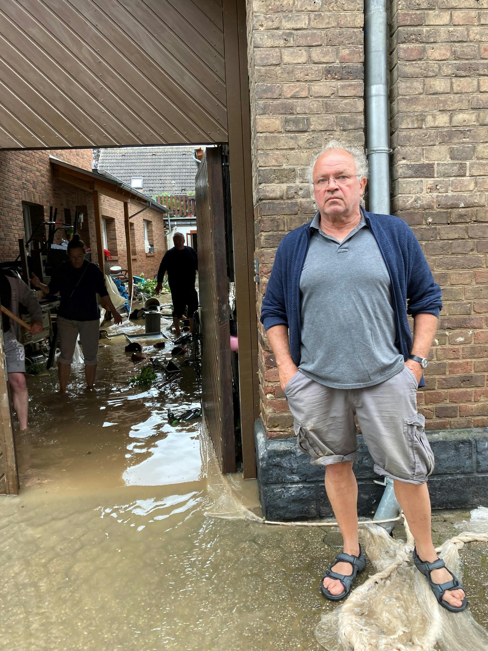 Karl Berger steht in der Nähe seines Geburtshauses in Erftstadt-Blessem im Wasser. 