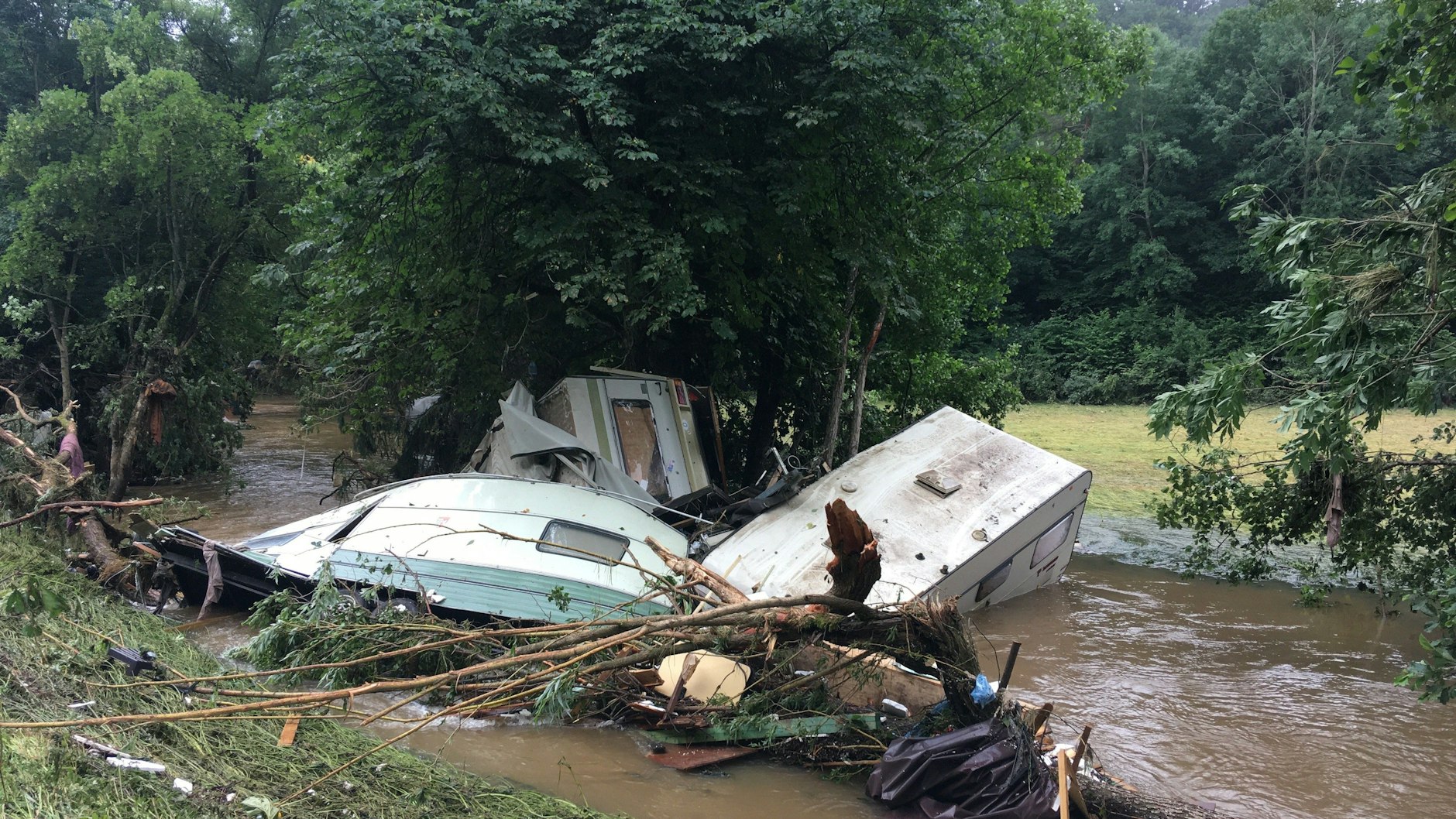 Zerstörte Wohnwagen liegen verkeilt in der Ahr bei Ahrdorf.