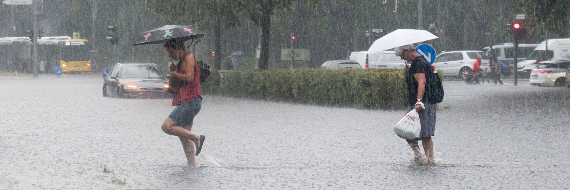 Fußgänger waten durch die überflutete Tiergartenstraße in Berlin.