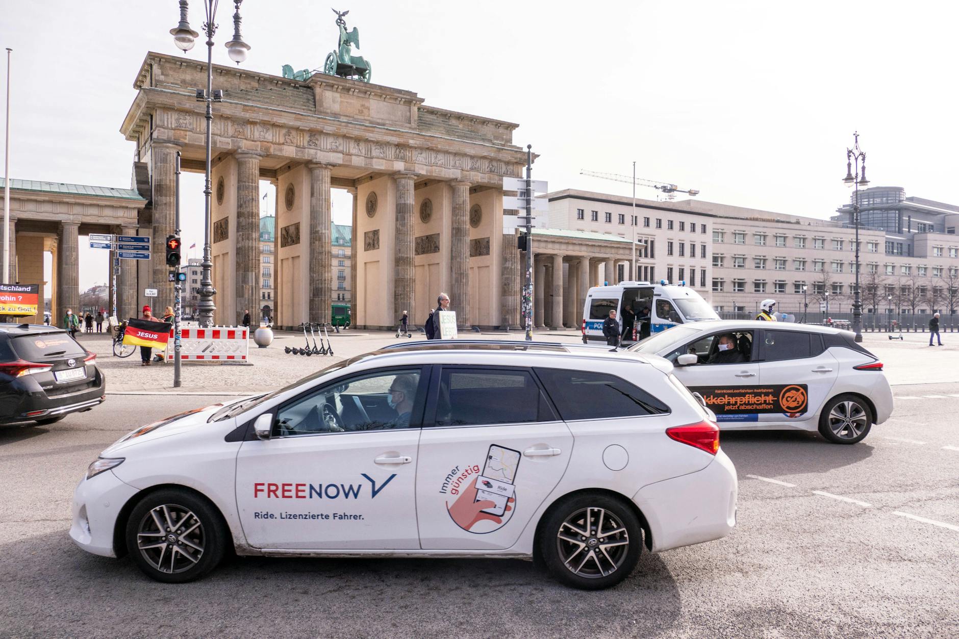 Meist preiswerter als das Taxi: Ein Free Now fährt in Berlin am Brandenburger Tor vorbei. Rechtlich gelten die Autos als Mietwagen mit Fahrer. In Berlin sind rund 5000 solcher Fahrzeuge unterwegs.