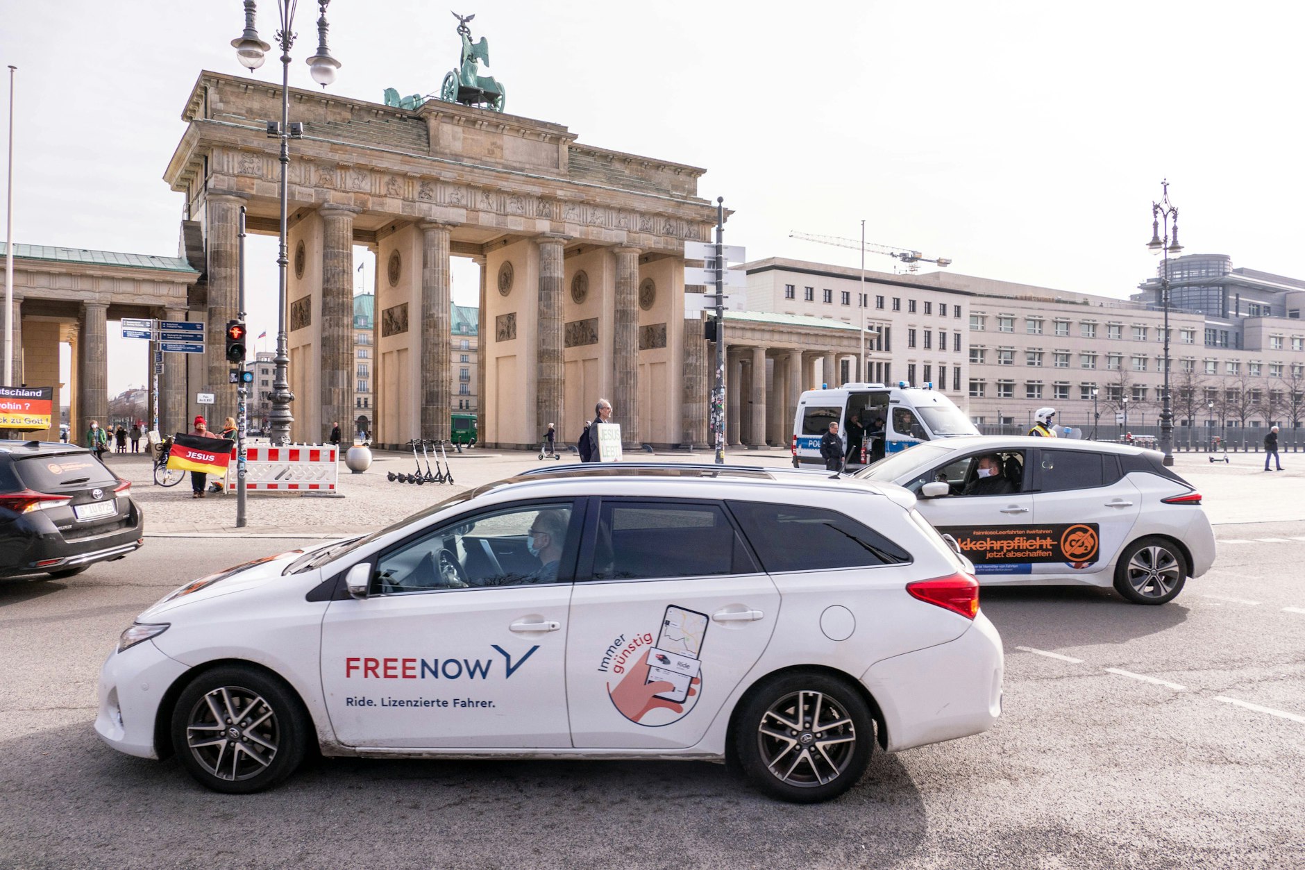 Meist preiswerter als das Taxi: Ein Free Now fährt in Berlin am Brandenburger Tor vorbei. Rechtlich gelten die Autos als Mietwagen mit Fahrer. In Berlin sind rund 5000 solcher Fahrzeuge unterwegs.