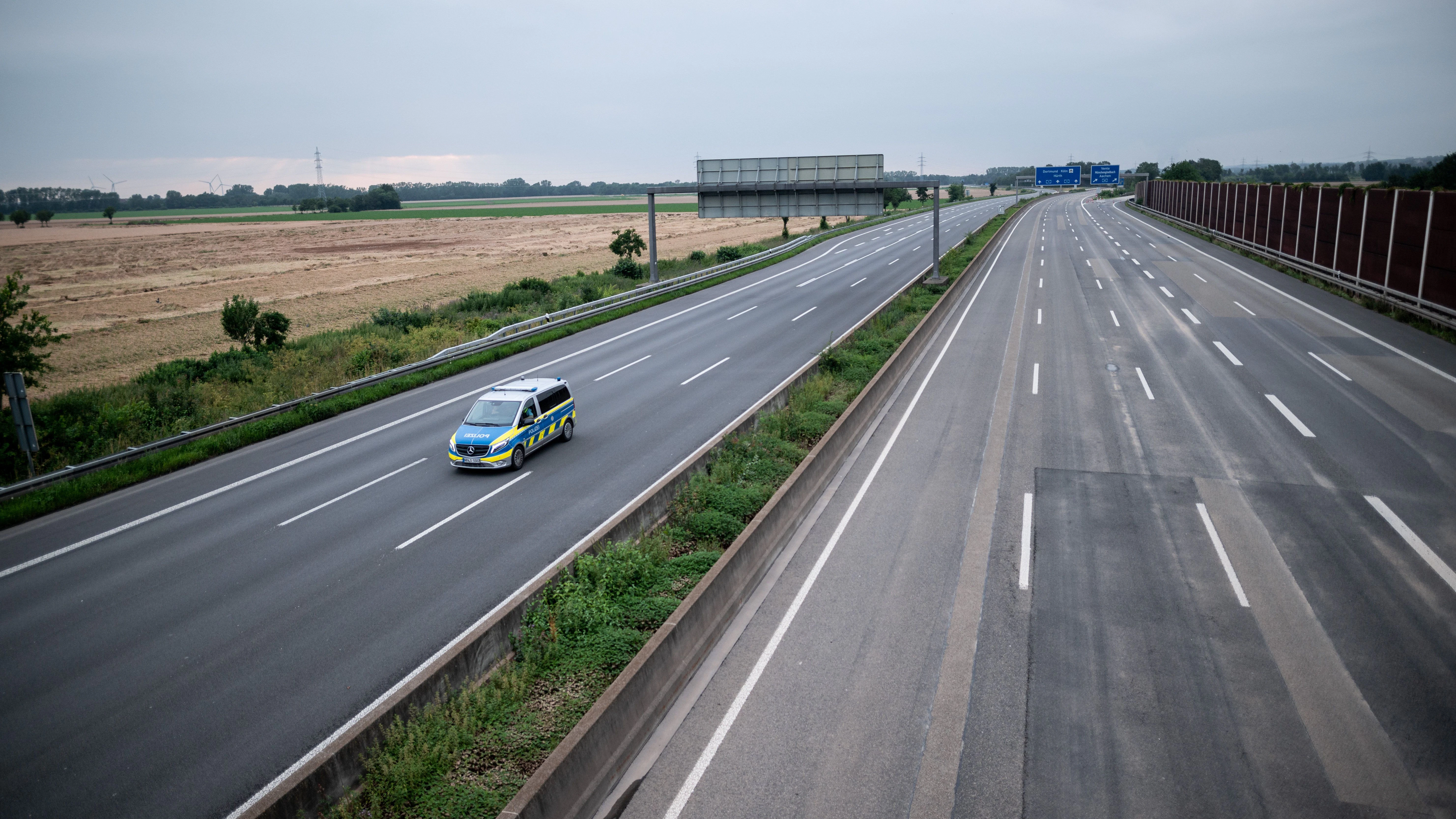 Ein Wagen der Polizei fährt über die gesperrte Autobahn A1 nahe Blessem in Erftstadt.
