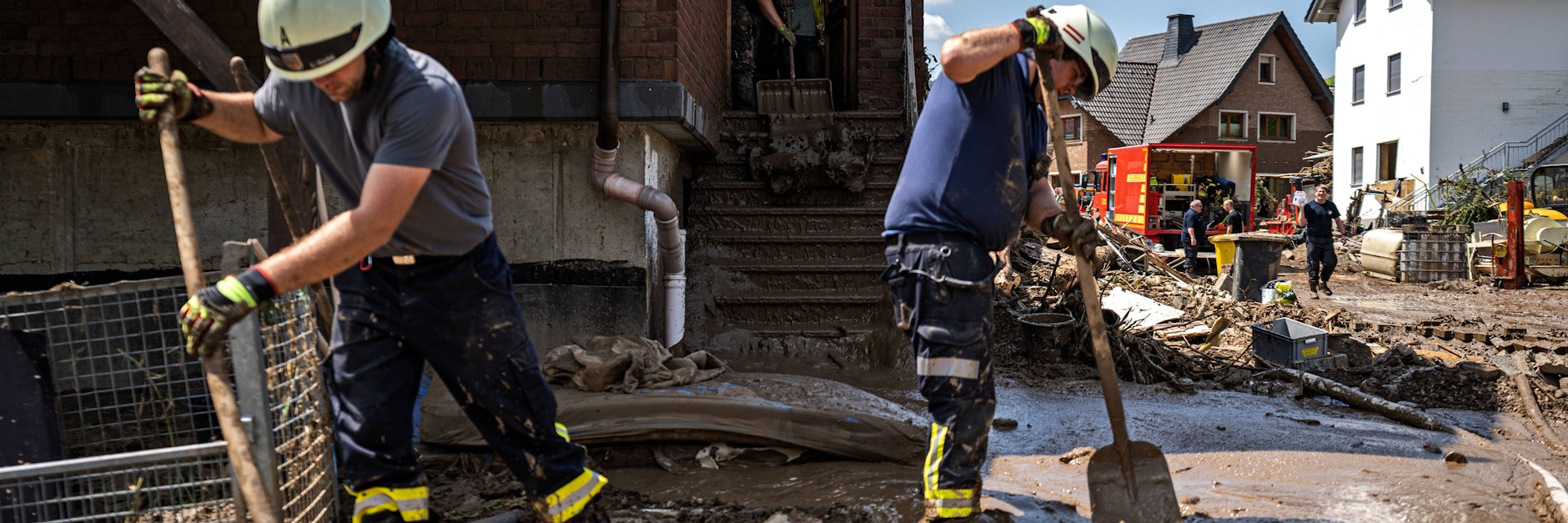 Aufräumarbeiten nach dem Hochwasser: Bewohner und Feuerwehr tragen Schlamm in der Stadt Marienthal ab.