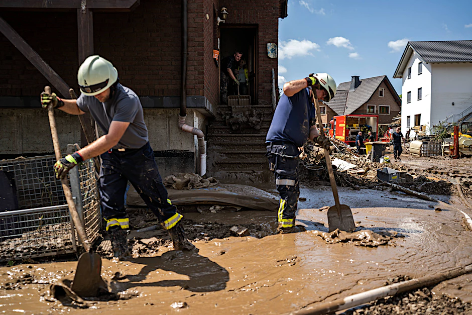 Aufräumarbeiten nach dem Hochwasser: Bewohner und Feuerwehr tragen Schlamm in der Stadt Marienthal ab.