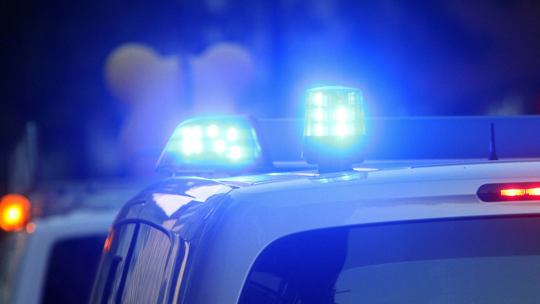 Einsatzwagen der Polizei stehen mit Blaulicht an einem Tatort (Symbolbild).