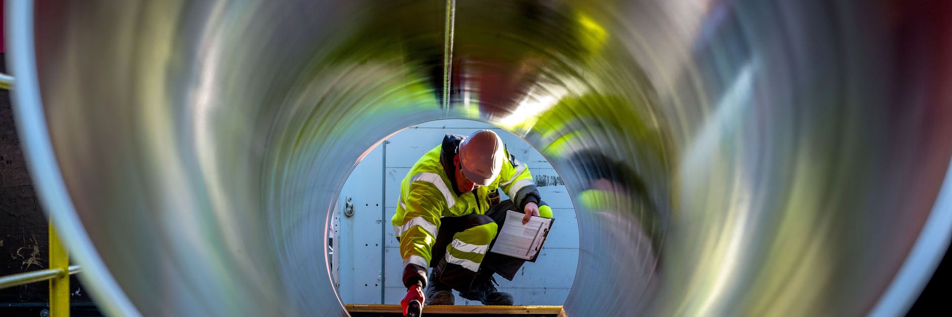 Ein Mitarbeiter prüft tonnenschwere Rohre für die zukünftige Ostsee-Pipeline.