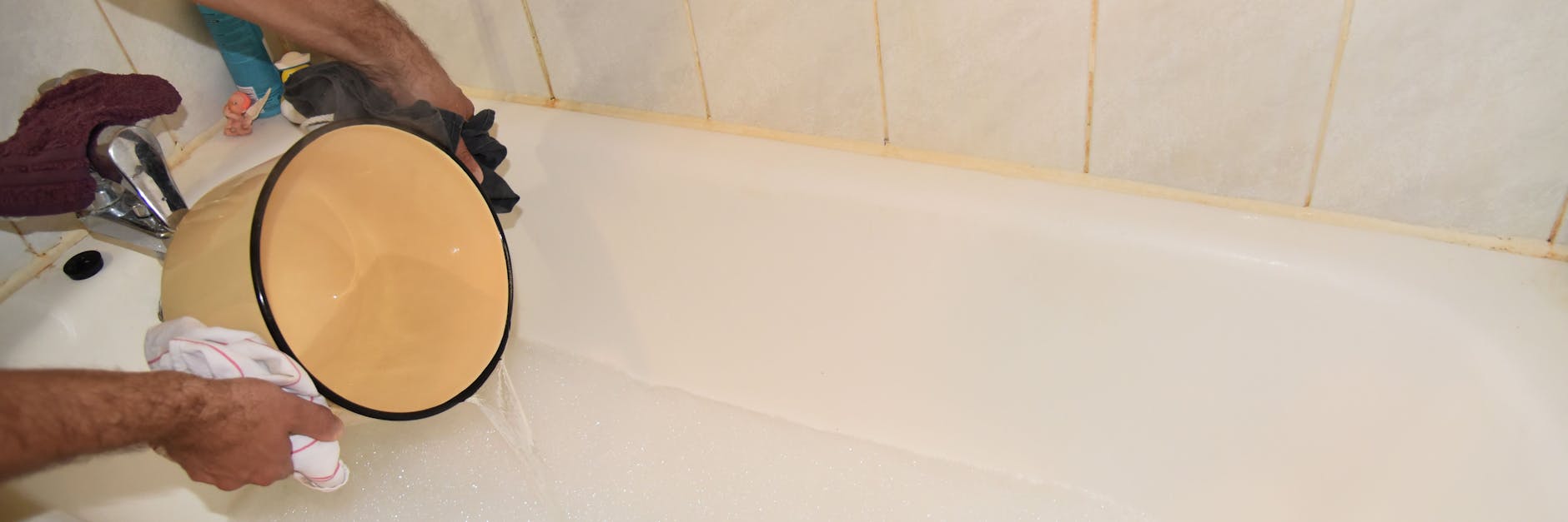 Ein Mann gießt kochend heißes Wasser aus einem Topf in die Badewanne und lässt sich so ein warmes Bad ein, weil im Sommer in der russischen Hauptstadt jedes Jahr für mehrere Tage die Fernwärme abgestellt wird. 