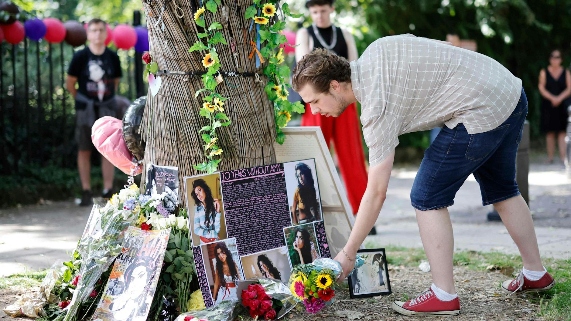 Fans legen Blumen für Amy Winehouse im Londoner Stadtteil Camden nieder.
