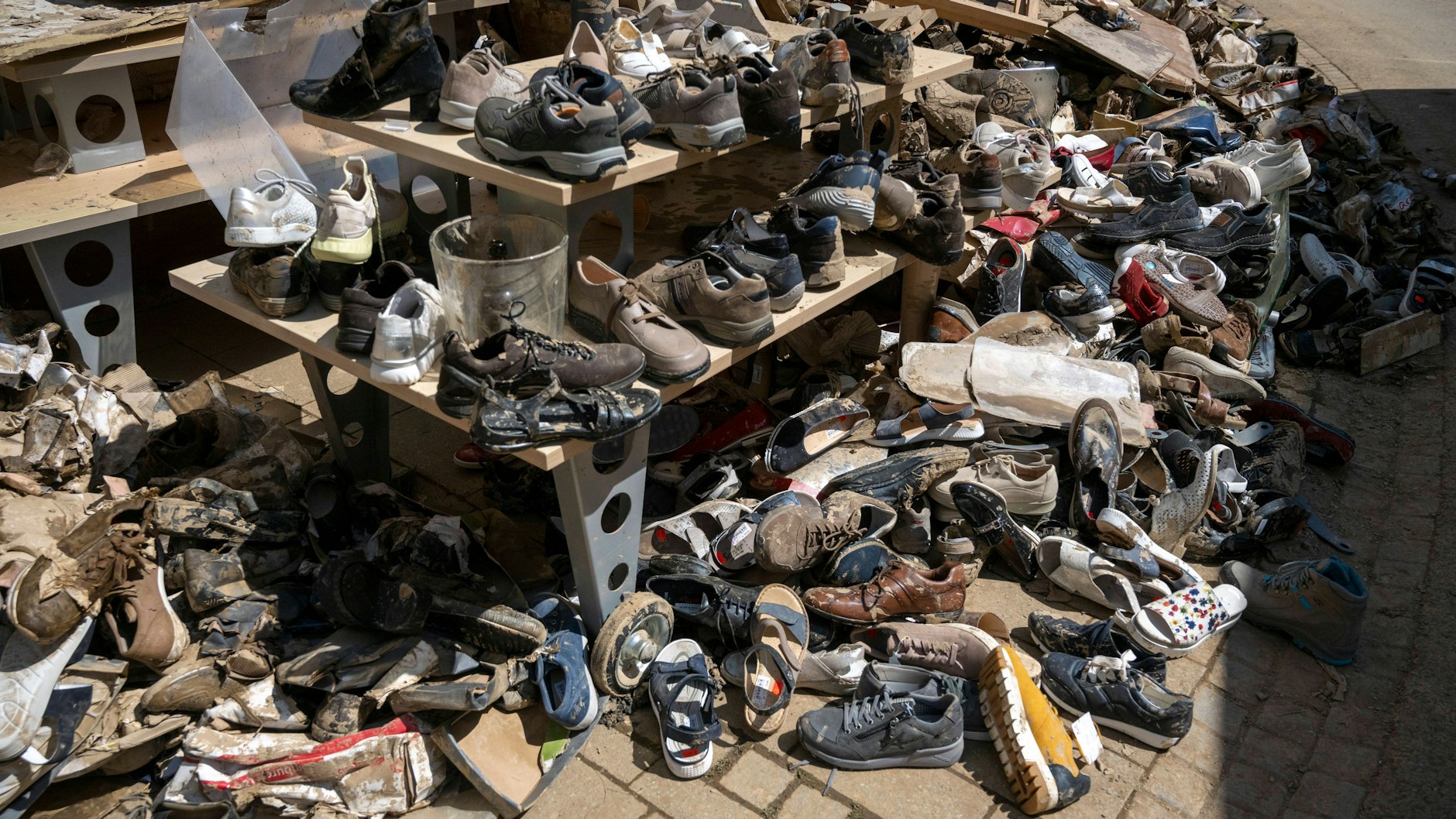 Vor einem Schuhgeschäft gestapelte, ruinierte Schuhe.&nbsp;