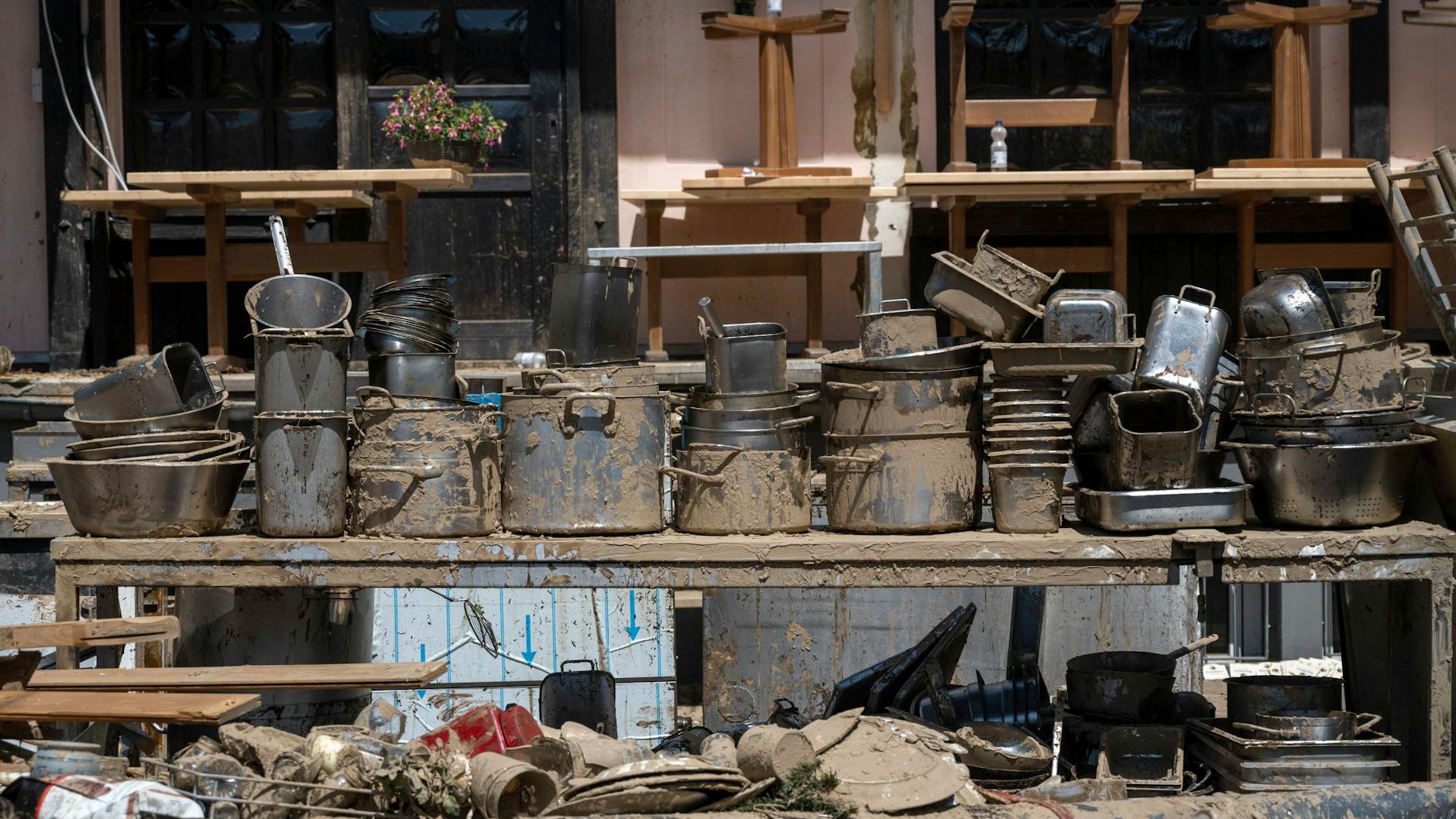 Vor einem Restaurant: Es wurde leergeräumt. Neben anderen nicht mehr brauchbaren Utensilien wurden die verschlammten Töpfe auf einem Tisch drapiert. 