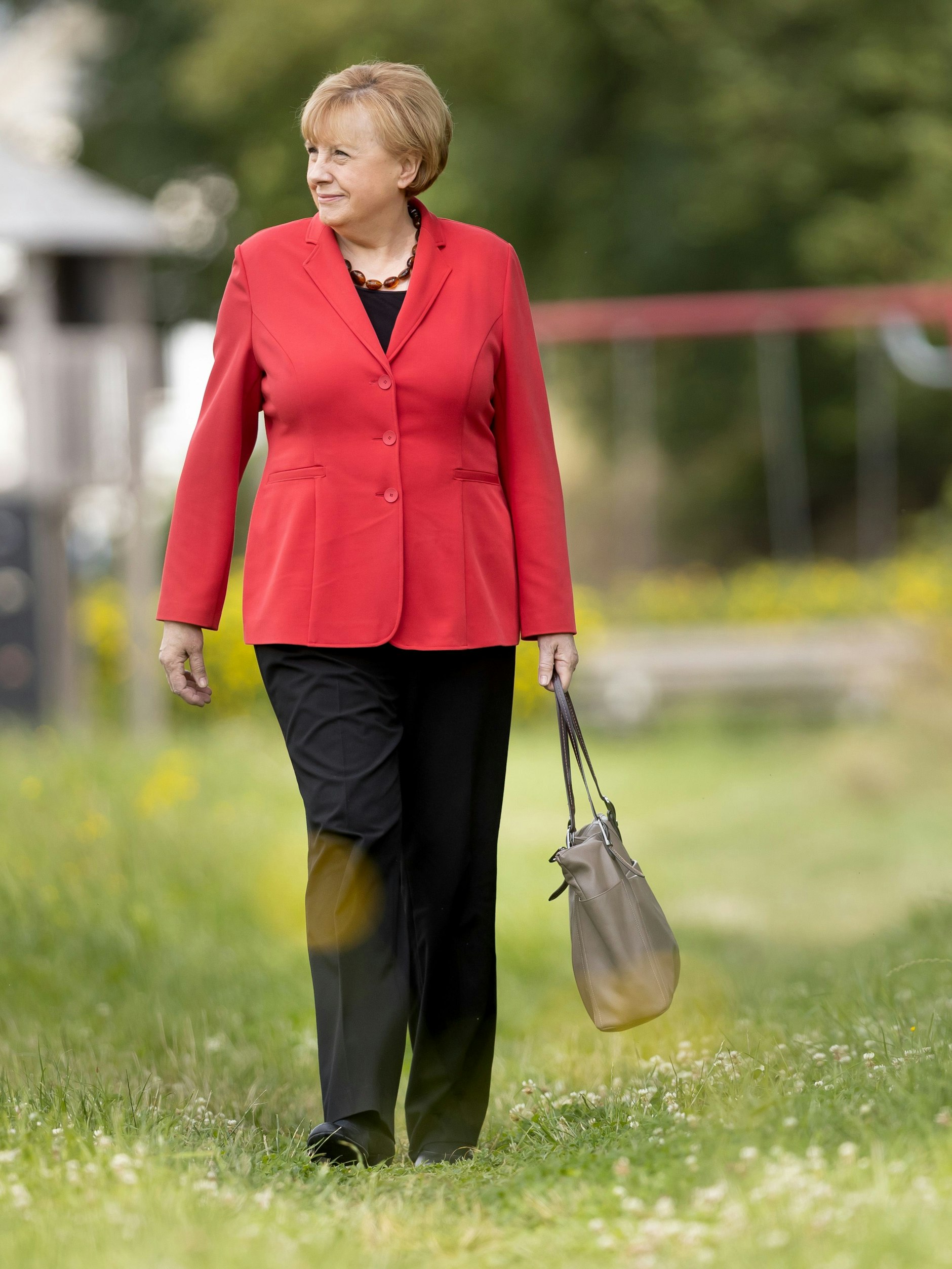 Zum Verwechseln ähnlich? Ursula Wanecki, Kanzlerinnen-Double, schlendert mit Handtasche.