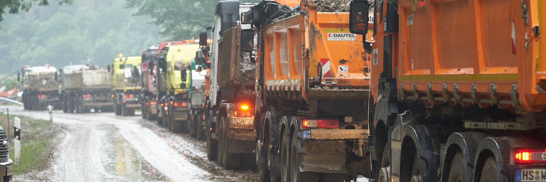  Kipplader stehen nahe Ahrbrück vor einem Zwischenlager für Müll und Bauschutt. Am Samstag begann es dort wieder zu regnen.