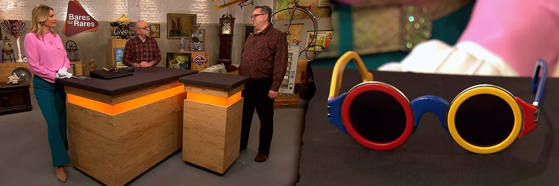 Diese skurrile Sonnenbrille kam bei „Bares für Rares“ unter den Hammer: Links: Expertin Bianca Berding, Moderator Horst Lichter und Kandidat Bernhard bei der Expertise.