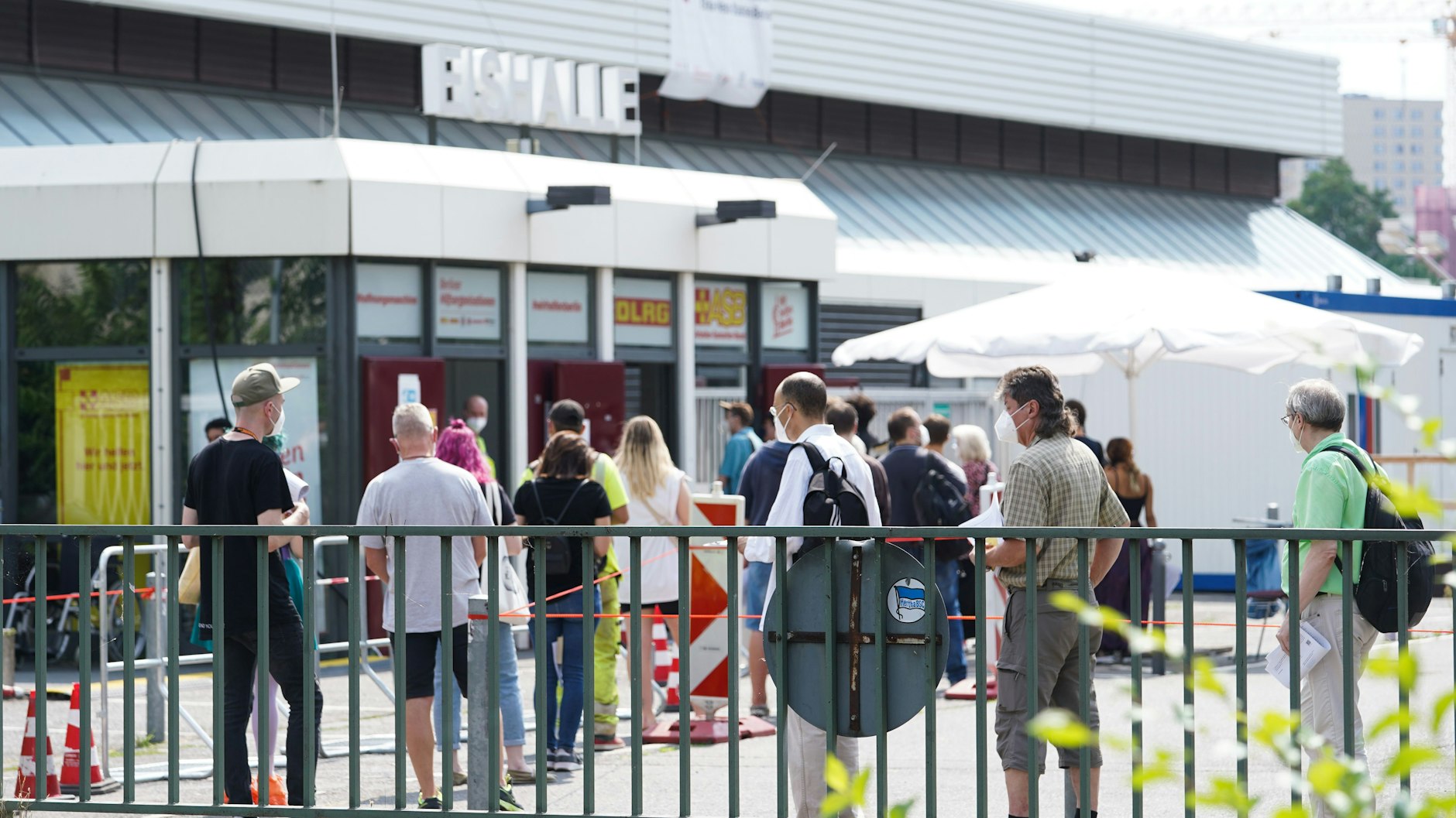 Menschen stehen in einer Warteschlange vor dem Impfzentrum im Erika-Heß-Eisstadion. Ende August wird das Impfzentrum geschlossen.