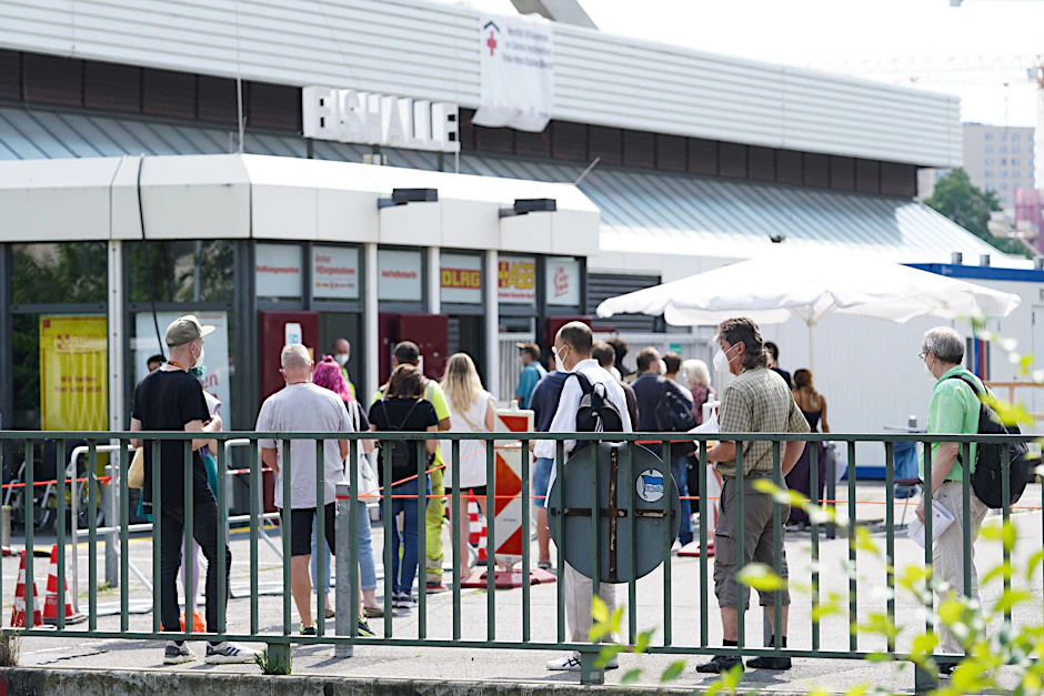 Menschen stehen in einer Warteschlange vor dem Impfzentrum im Erika-Heß-Eisstadion. Ende August wird das Impfzentrum geschlossen.