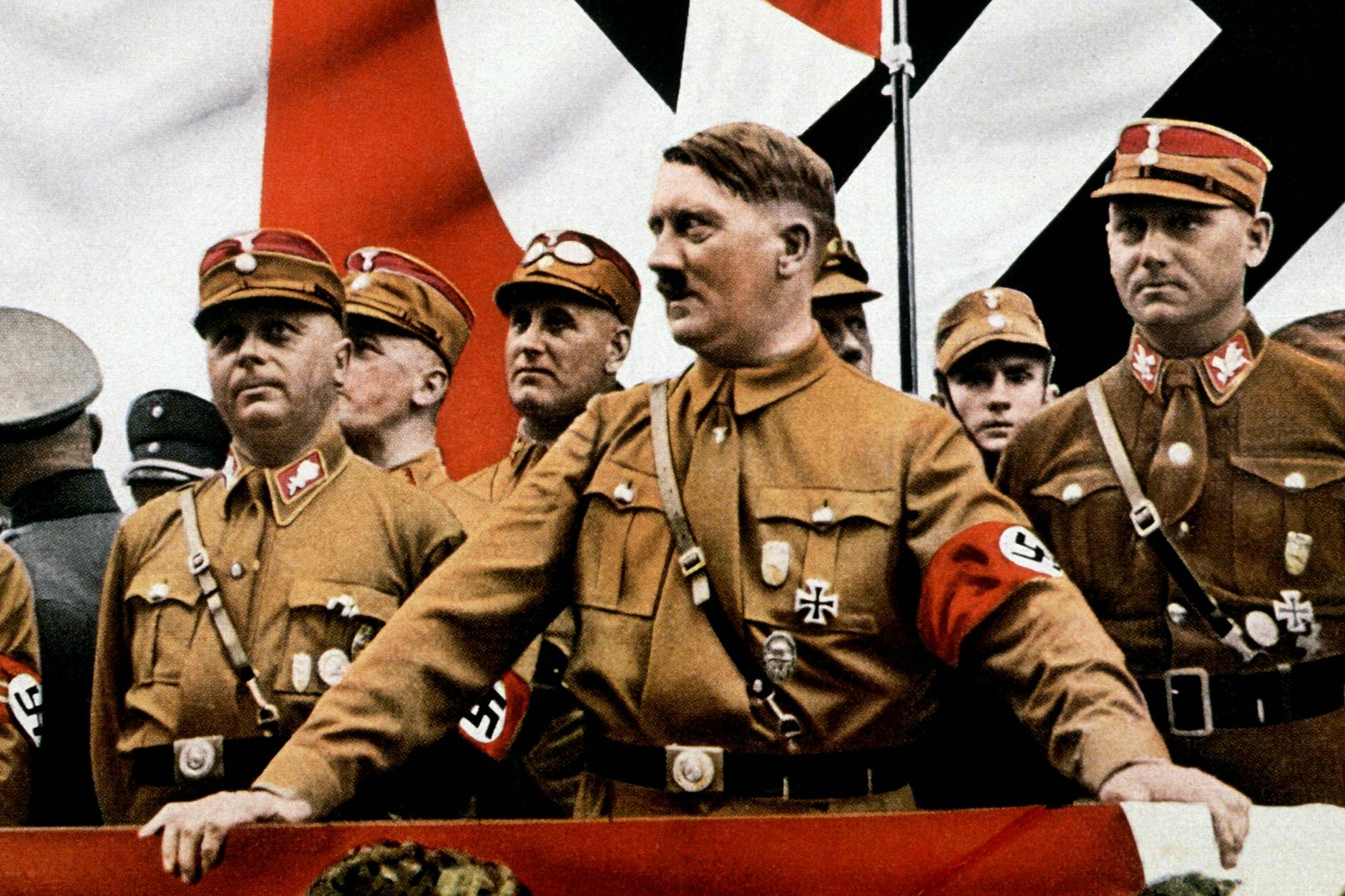 Adolf Hitler und andere Führer der SA tragen während einer Kundgebung 1935 das Braunhemd. Hitler verzichtete generell auf jegliche Rangabzeichen.