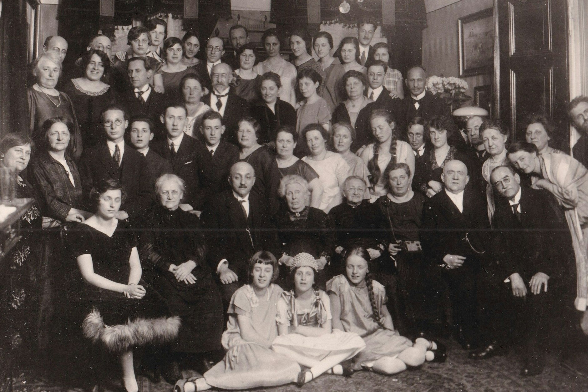 Foto einer Geburtstagsfeier der Familie Katz, aufgenommen 1926 in Berlin. Richard und Herta Katz stehen in der zweiten Reihe rechts neben der Frau mit Zöpfen. Tochter Romana sitzt links vorn. <br><br>
