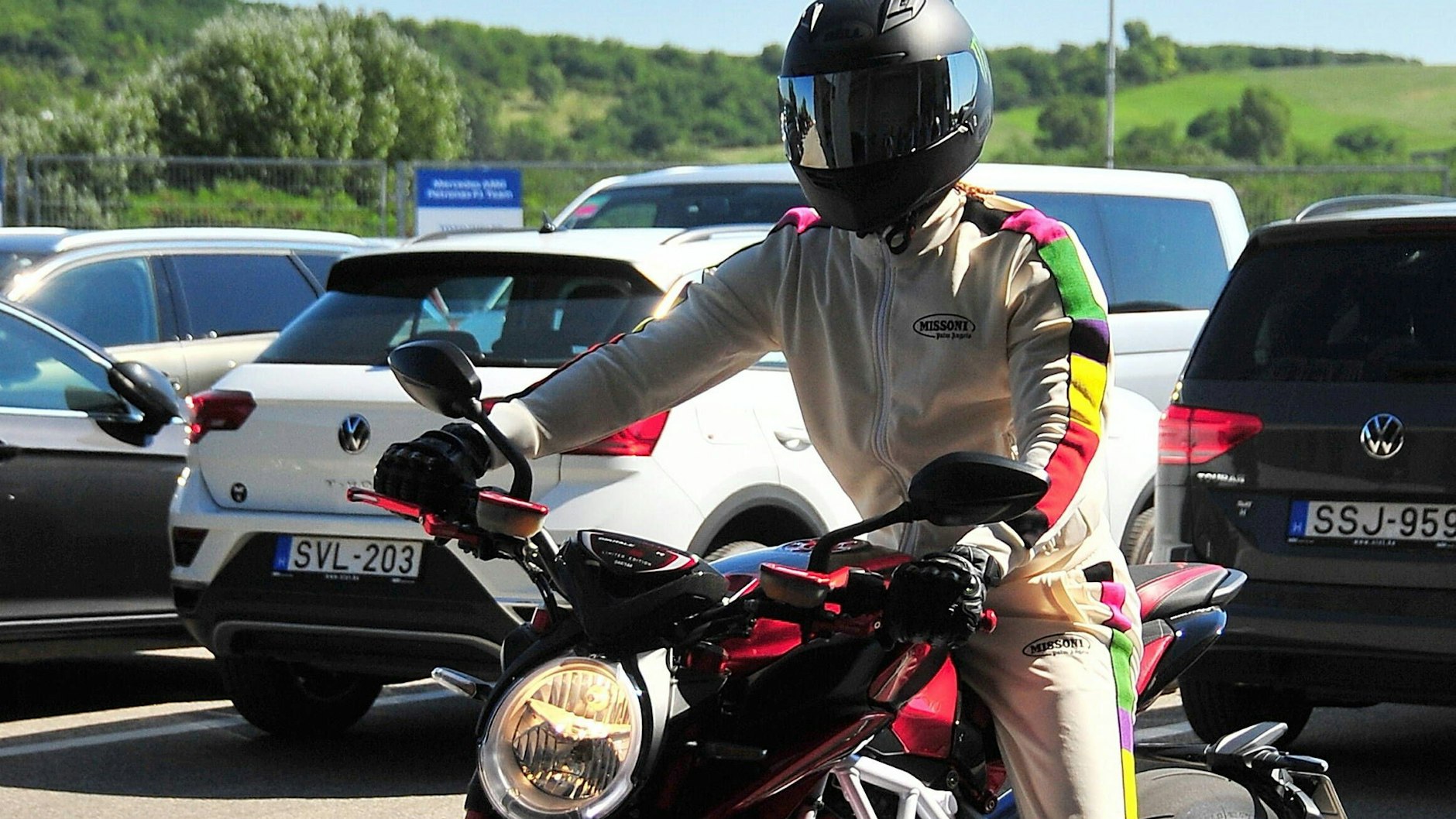 Lewis Hamilton kam auf dem Motorrad zur Strecke&nbsp;– und in einem weißen mit der Regebogenfahne geschmückten Overall.&nbsp;