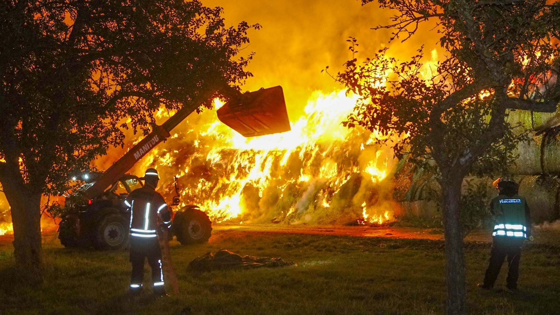 Einsatzkräfte der Feuerwehr löschen einen Brand von rund 400 Strohballen in Gundelsheim.