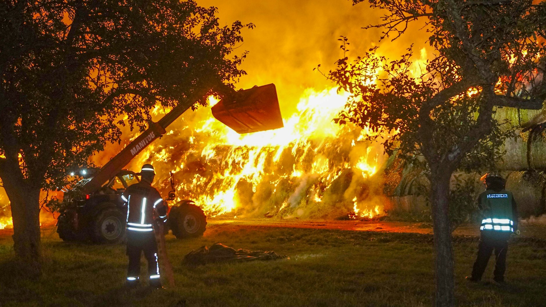 Einsatzkräfte der Feuerwehr löschen einen Brand von rund 400 Strohballen in Gundelsheim.
