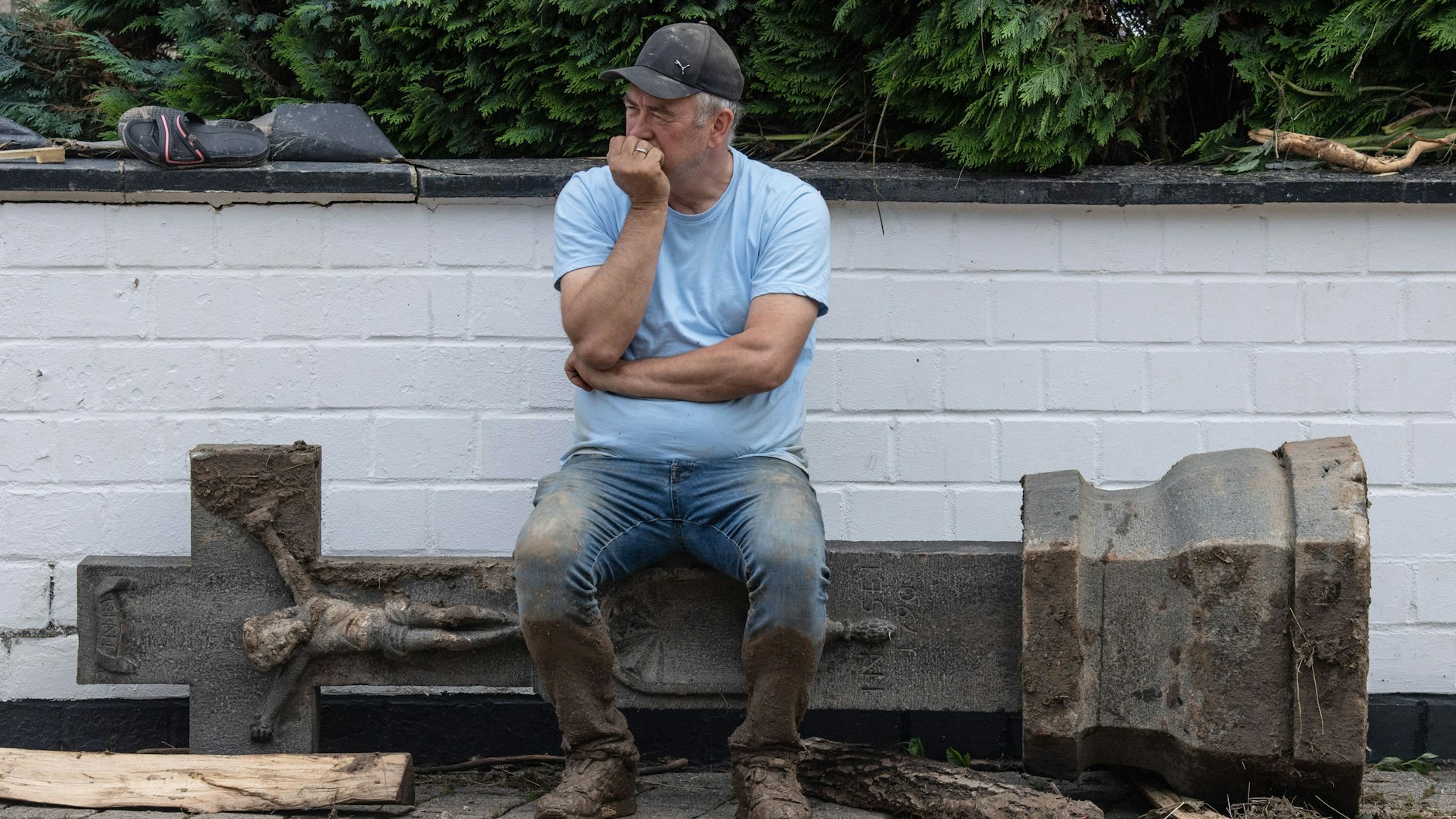 Wenige Stunden nachdem eine gewaltige Flutwelle sein Hotel zerstört hat, sitzt der Gastronom Wolfgang Ewerts aus Insul auf einem steinernen Betstock