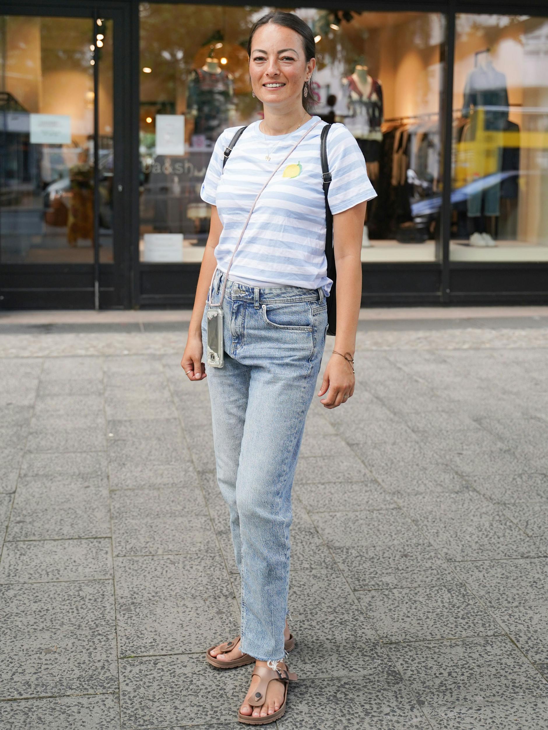 Die Erzieherin Hanite ist auf dem Weg zu einem Termin. Ihr Outfit kommt unprätentiös und sommerlich daher: gestreiftes T-Shirt von H&M, Jeans von C&A und Sandalen von Birkenstock.