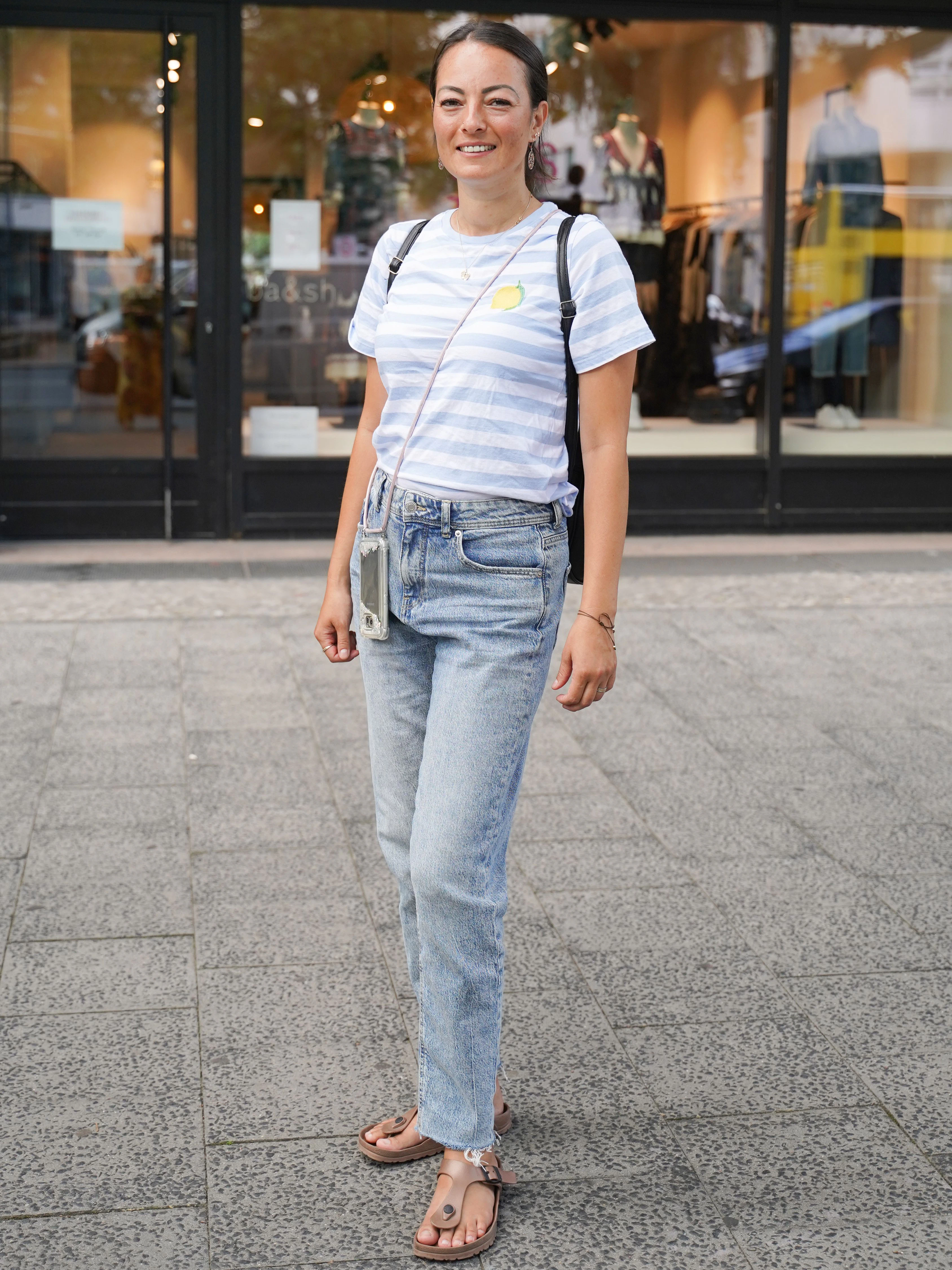 Die Erzieherin Hanite ist auf dem Weg zu einem Termin. Ihr Outfit kommt unprätentiös und sommerlich daher: gestreiftes T-Shirt von H&M, Jeans von C&A und Sandalen von Birkenstock.