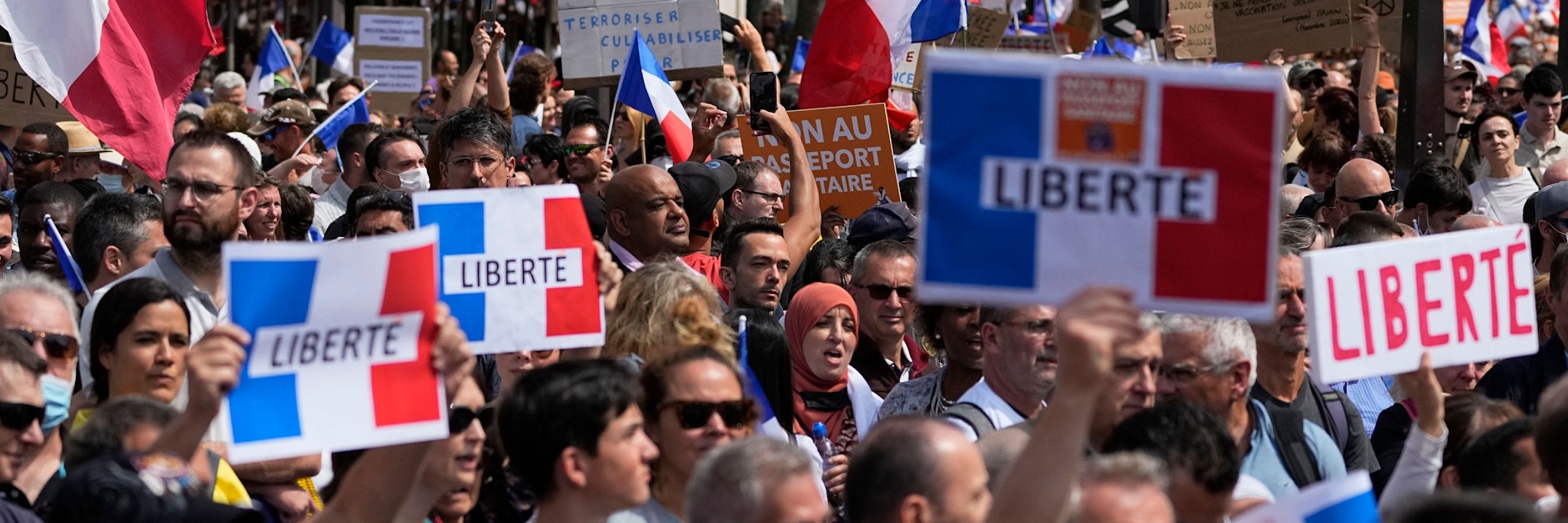 Demonstranten in Paris halten Schilder mit der Aufschrift „Liberté“ („Freiheit“) hoch.