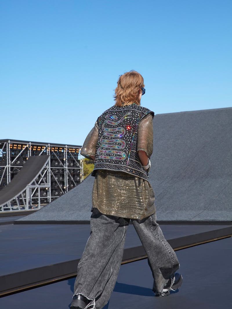 Die weite Slimane-Jeans hat einen langen, zerfetzten Saum. 