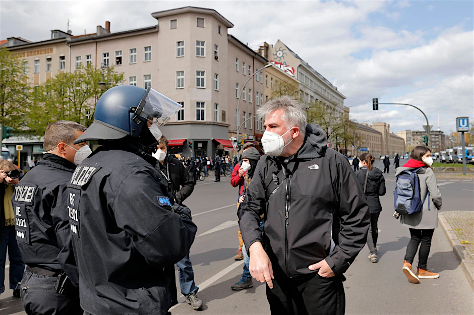 DJU-Landesgeschäftsführer Jörg Reichel spricht mit einem Polizisten auf einer Demonstration im April.
