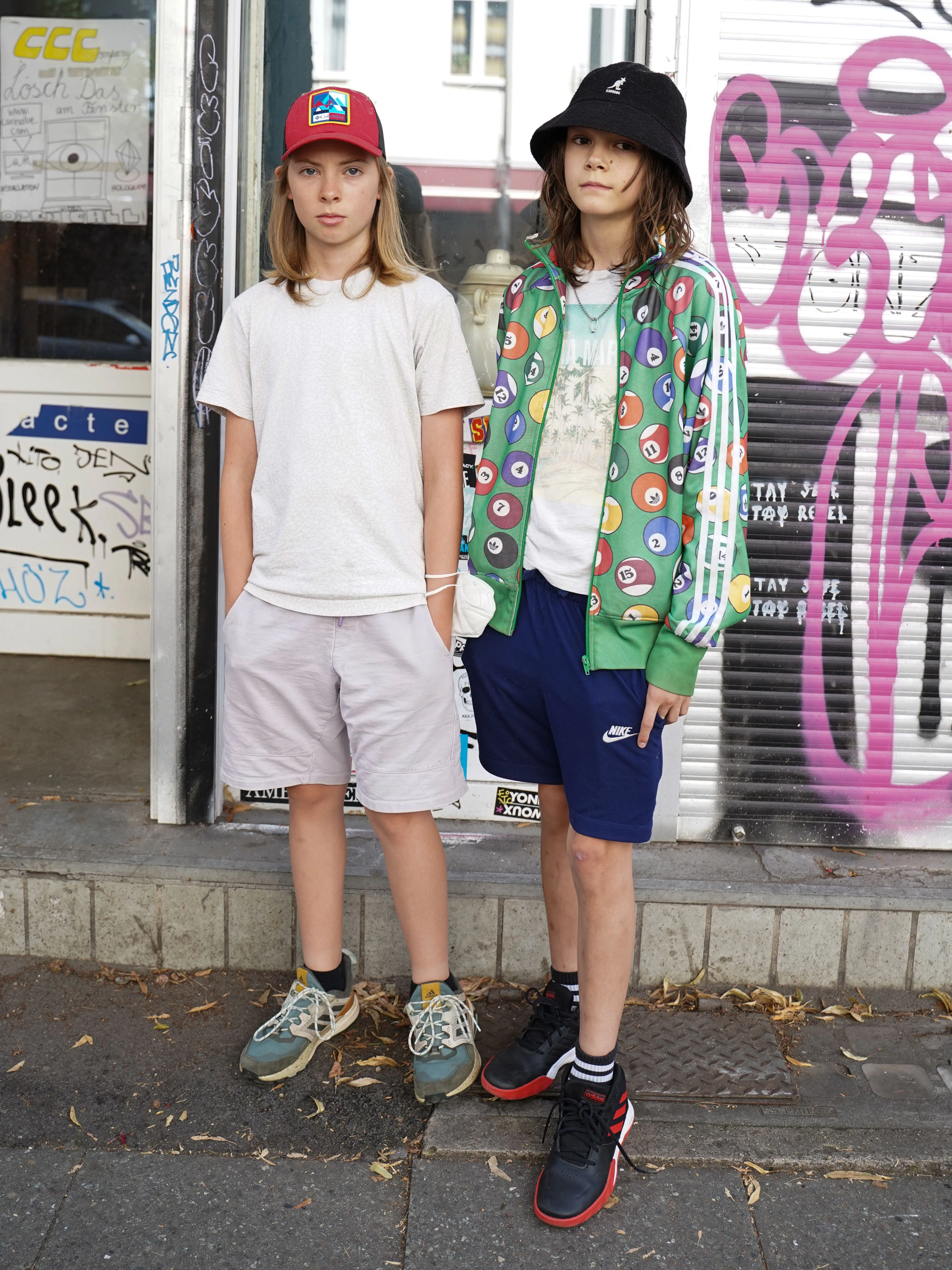 „Klar“, sagen sie, als wir ein Foto machen wollen. Anton trägt Zara-Shorts zu Uniqlo-Shirt und Columbia-Cap, Nico eine Trainingsjacke von Adidas Originals mit Billard-Print, Shorts von Nike und einen Bucket Hat von Kangol.