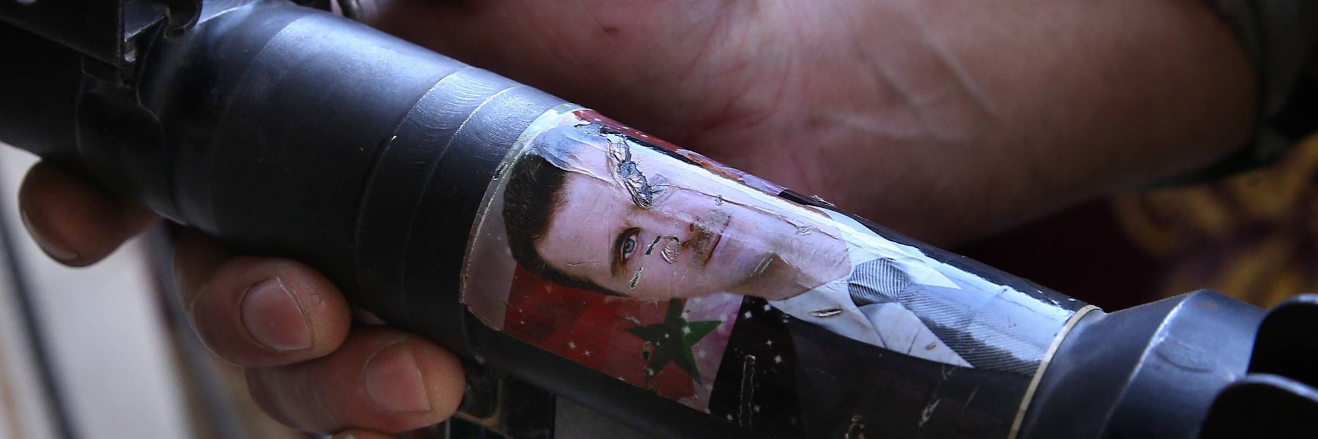 Eine Granate mit einem Bild des syrischen Diktators Assad in der Hand eines Soldaten.