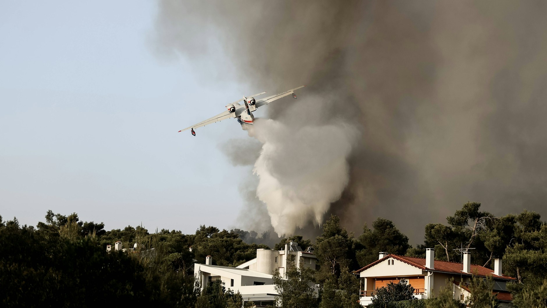 In Ano Varibobi im Norden von Athen ist ein Löschflugzeug bei der Arbeit.