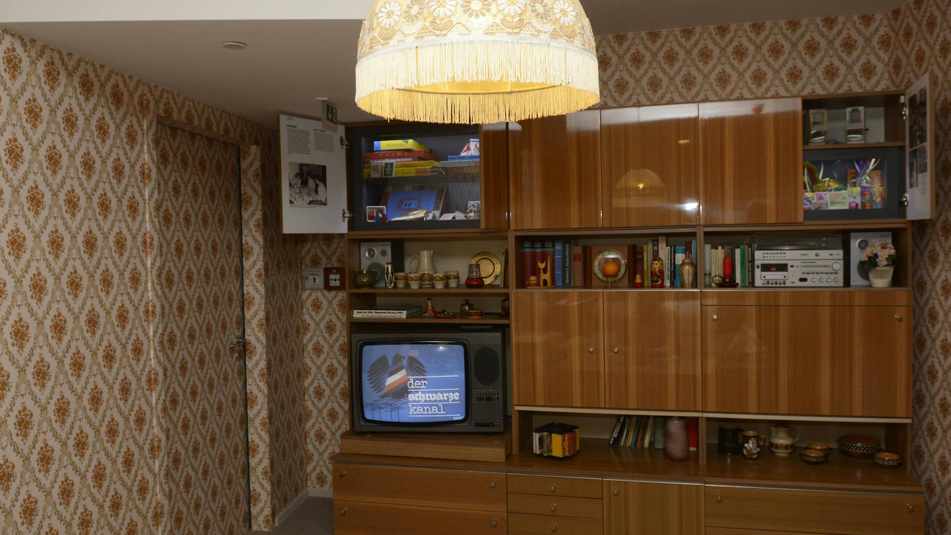 Ein DDR-Wohnzimmer mit Blümchentapete und Schrankwand, so wie es im DDR-Museum in Mitte gezeigt wird: Auch das versteht so mancher unter Ost-Charme, allerdings meist im negativen Sinn.