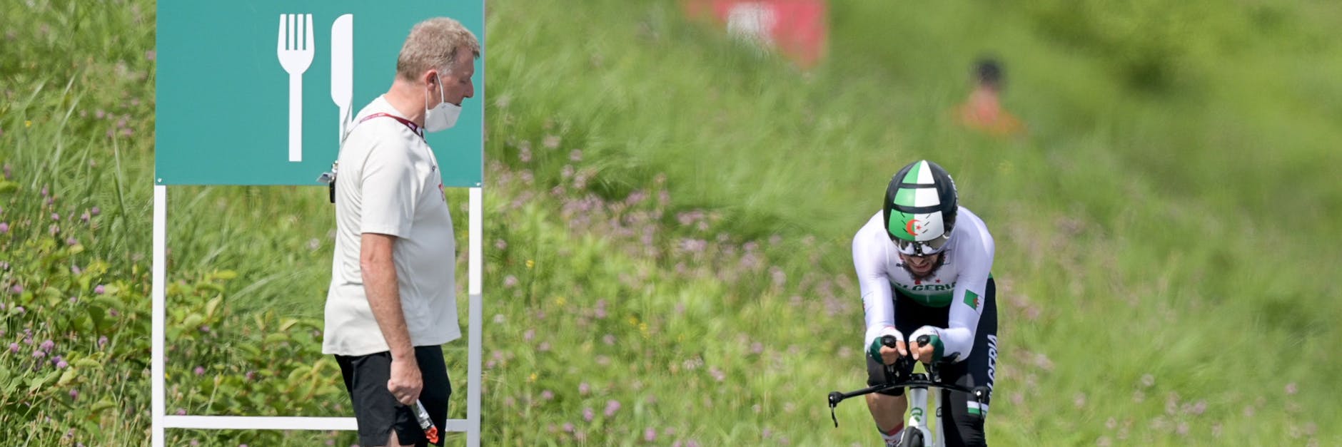 Patrick Moster, Sportdirektor vom BDR (Bund Deutscher Radfahrer), steht am Streckenrand neben Azzedine Lagab aus Algerien in Aktion beim Zeitfahren. 