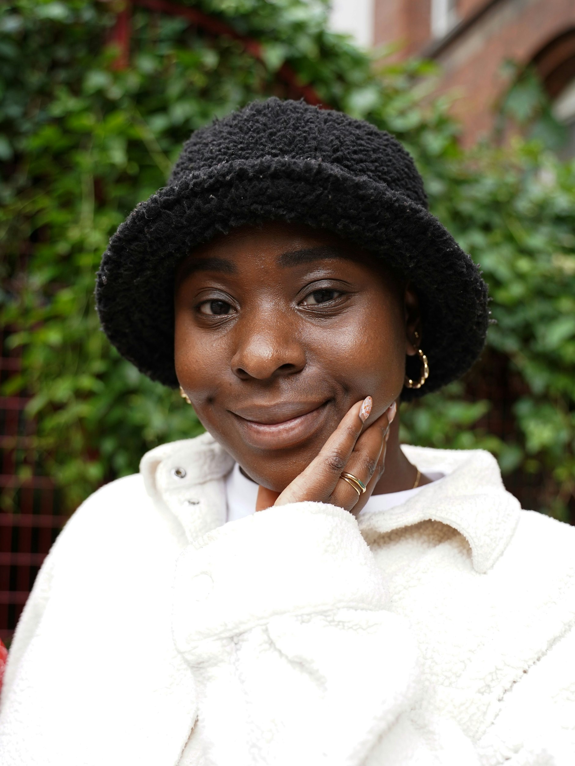 Gifty trägt einen flauschigen Bucket Hat von Asos und Schmuck von Andotherstories.