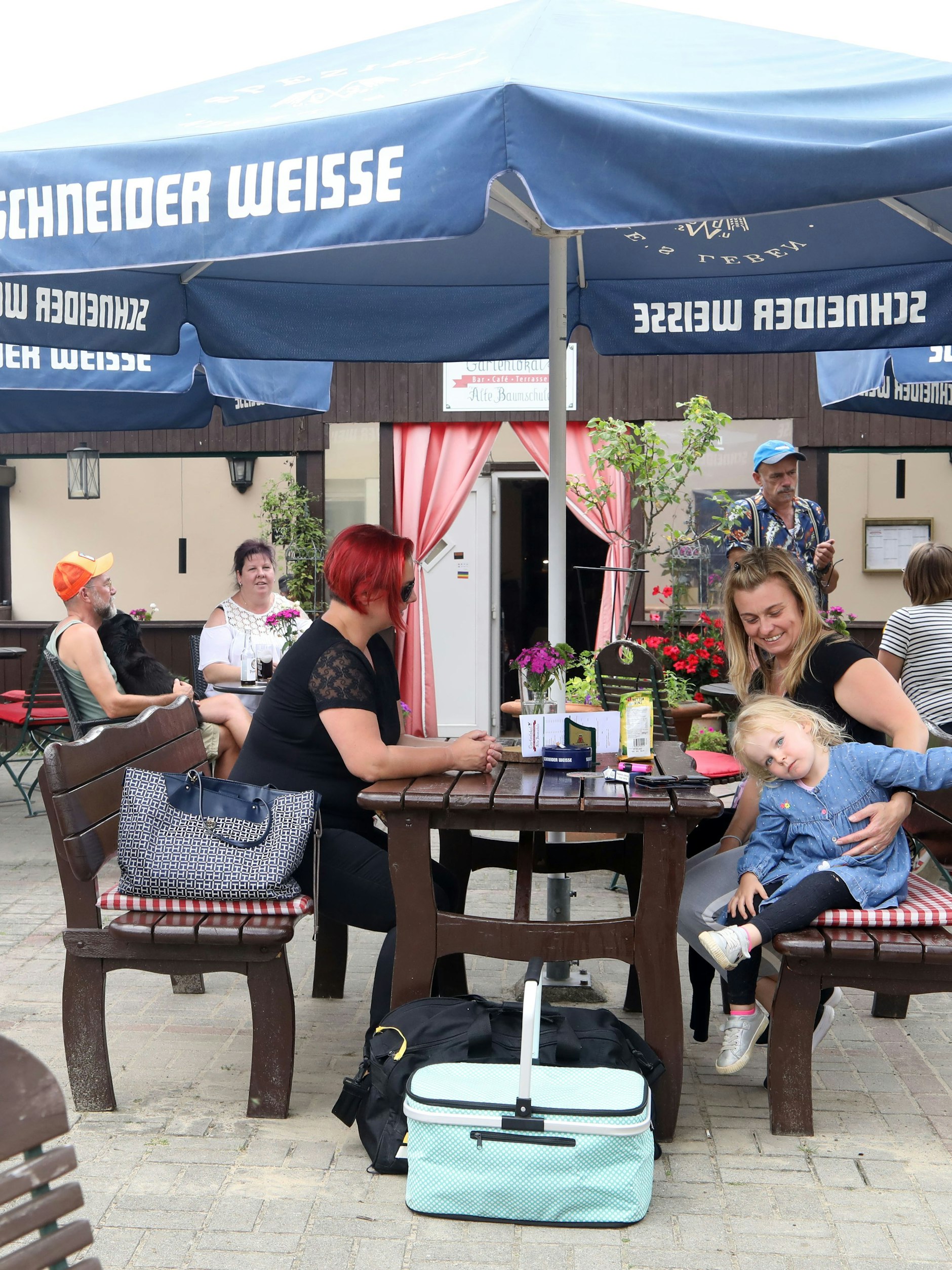 In einem Gartenlokal treffen oft die verschiedensten Menschen aufeinander. Lotti ( 3) ist heute der jüngste Gast. Mit ihrer Mama kommt sie öfter auf ein Eis, oder ein Wasser mit Action. Also Sprudel. 