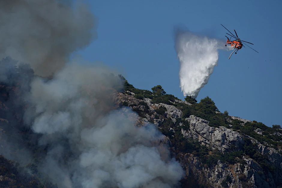 Ein Hubschrauber wirft über einem Feuer in der Nähe des Dorfes Malakasa nördlich von Athen Wasser ab.&nbsp;