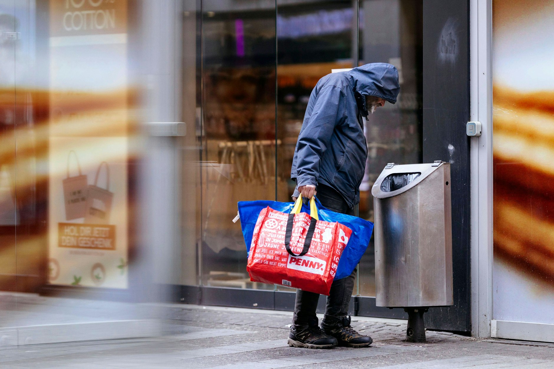 Ein Flaschensammler blickt in einen Abfallbehälter (Symbolbild). In der Berliner City suchen zahlreiche Menschen, die von Armut betroffen sind, nach Pfandflaschen.